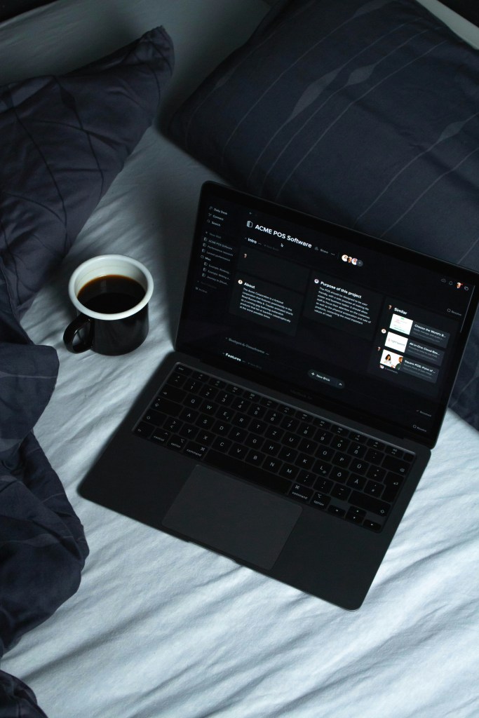 Freelance computer on bed with black coffee
